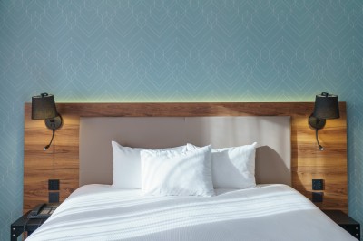 Salle de bain moderne avec lavabo, miroir éclairé, baignoire et murs en marbre.