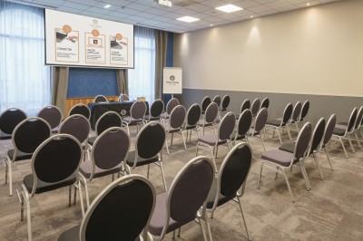 Salle de bain moderne avec lavabo, miroir éclairé, baignoire et murs en marbre.