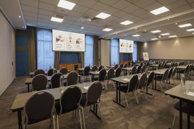 Salle de bain moderne avec lavabo, miroir éclairé, baignoire et murs en marbre.