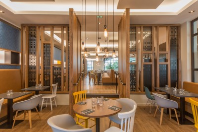Salle de bain moderne avec lavabo, miroir éclairé, baignoire et murs en marbre.