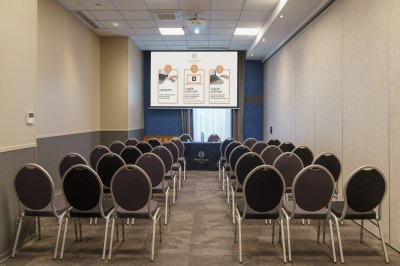 Salle de bain moderne avec lavabo, miroir éclairé, baignoire et murs en marbre.