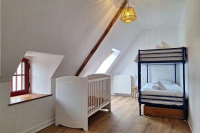 Miniature Chambre enfant du gîte Arbre majestueux au centre d'une prairie verdoyante, éclairé par le soleil filtrant à travers ses branches.