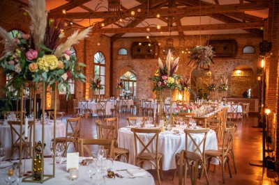 Chaises longues alignées devant un mur en pierre, entourées de grands arbres sous un ciel bleu clair.