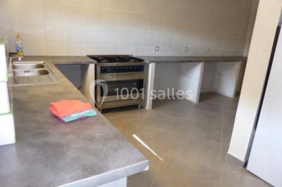 Vignes verdoyantes sous un ciel bleu dégagé, bordées d'arbres et d'un chemin de terre.