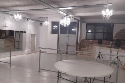 Salle lumineuse avec canapés, tables basses, bar moderne et décoration minimaliste, sous un plafond en verrière.