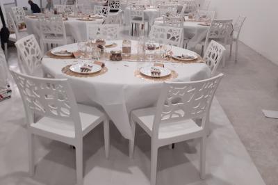 Salle lumineuse avec canapés, tables basses, bar moderne et décoration minimaliste, sous un plafond en verrière.