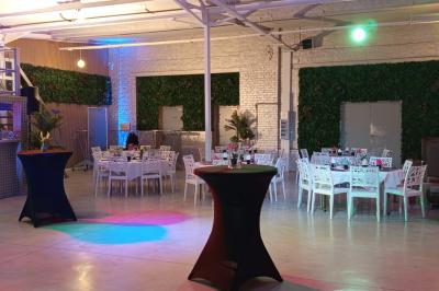 Salle lumineuse avec canapés, tables basses, bar moderne et décoration minimaliste, sous un plafond en verrière.