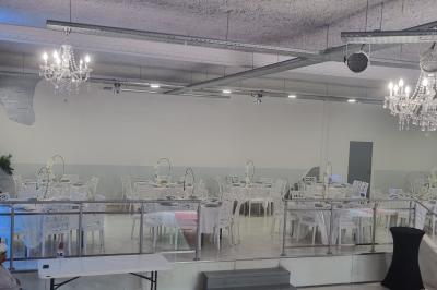 Salle lumineuse avec canapés, tables basses, bar moderne et décoration minimaliste, sous un plafond en verrière.