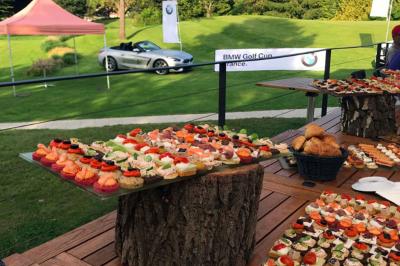 Paysage de terrain de golf avec pelouses verdoyantes, drapeau sur le green et maisons en arrière-plan.