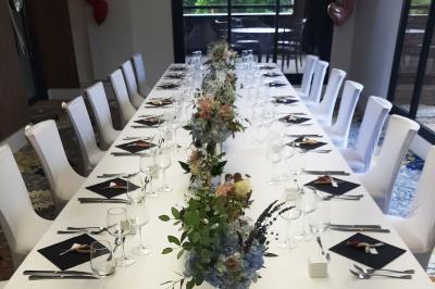 Paysage de terrain de golf avec pelouses verdoyantes, drapeau sur le green et maisons en arrière-plan.