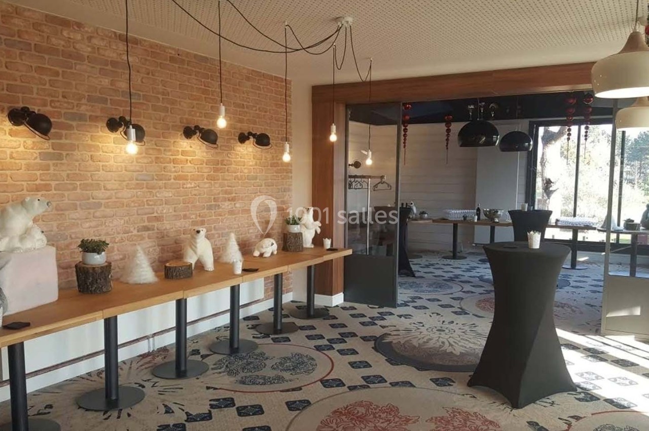 Salle décorée avec des ours polaires en peluche, des luminaires suspendus et des tables hautes sur un tapis à motifs.
