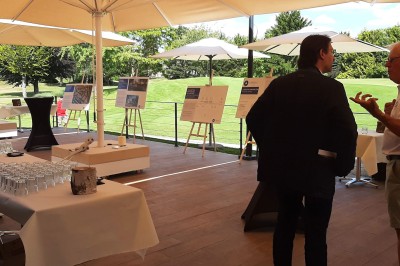 Paysage hivernal avec un terrain enneigé, des tables extérieures et un coucher de soleil vibrant au-dessus d'un lac.