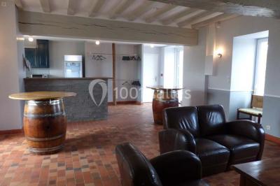 Chambre avec lit double, tête de lit en bois, bureau, chaise, robe blanche sur un mannequin et tableau coloré au mur.