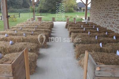 Chambre avec lit double, tête de lit en bois, bureau, chaise, robe blanche sur un mannequin et tableau coloré au mur.