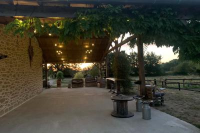 Chambre avec lit double, tête de lit en bois, bureau, chaise, robe blanche sur un mannequin et tableau coloré au mur.