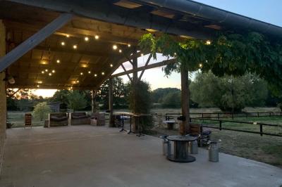 Chambre avec lit double, tête de lit en bois, bureau, chaise, robe blanche sur un mannequin et tableau coloré au mur.