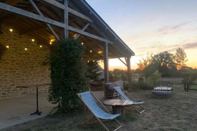 Chambre avec lit double, tête de lit en bois, bureau, chaise, robe blanche sur un mannequin et tableau coloré au mur.