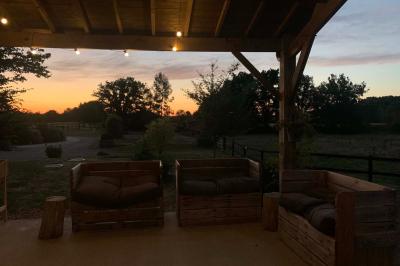Chambre avec lit double, tête de lit en bois, bureau, chaise, robe blanche sur un mannequin et tableau coloré au mur.