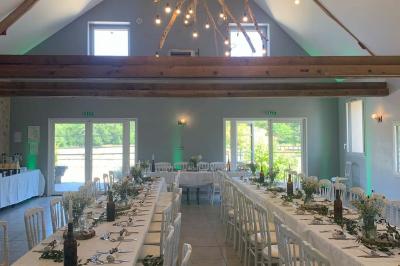 Chambre avec lit double, tête de lit en bois, bureau, chaise, robe blanche sur un mannequin et tableau coloré au mur.