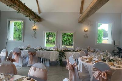 Chambre avec lit double, tête de lit en bois, bureau, chaise, robe blanche sur un mannequin et tableau coloré au mur.