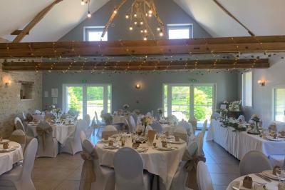 Chambre avec lit double, tête de lit en bois, bureau, chaise, robe blanche sur un mannequin et tableau coloré au mur.