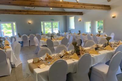 Chambre avec lit double, tête de lit en bois, bureau, chaise, robe blanche sur un mannequin et tableau coloré au mur.