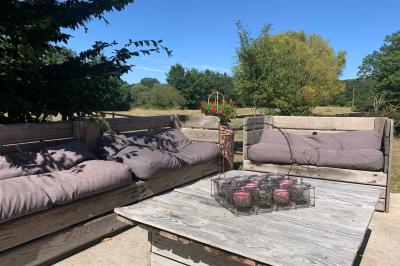 Chambre avec lit double, tête de lit en bois, bureau, chaise, robe blanche sur un mannequin et tableau coloré au mur.