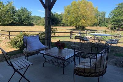 Chambre avec lit double, tête de lit en bois, bureau, chaise, robe blanche sur un mannequin et tableau coloré au mur.