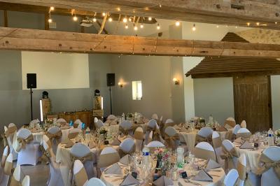 Chambre avec lit double, tête de lit en bois, bureau, chaise, robe blanche sur un mannequin et tableau coloré au mur.