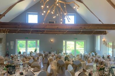 Chambre avec lit double, tête de lit en bois, bureau, chaise, robe blanche sur un mannequin et tableau coloré au mur.