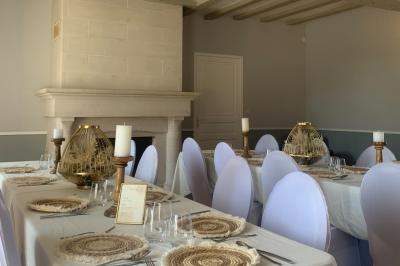 Chambre avec lit double, tête de lit en bois, bureau, chaise, robe blanche sur un mannequin et tableau coloré au mur.