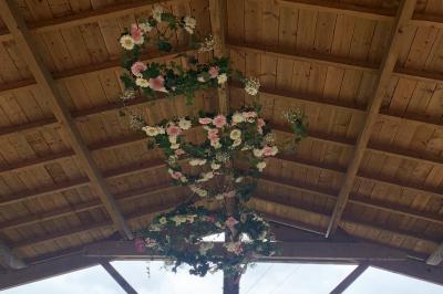 Chambre avec lit double, tête de lit en bois, bureau, chaise, robe blanche sur un mannequin et tableau coloré au mur.