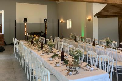 Chambre avec lit double, tête de lit en bois, bureau, chaise, robe blanche sur un mannequin et tableau coloré au mur.