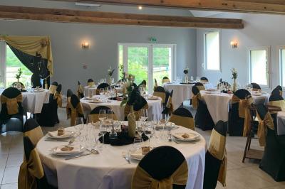 Chambre avec lit double, tête de lit en bois, bureau, chaise, robe blanche sur un mannequin et tableau coloré au mur.