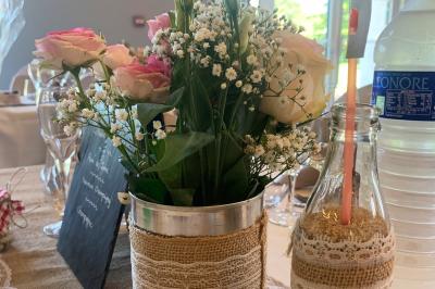 Chambre avec lit double, tête de lit en bois, bureau, chaise, robe blanche sur un mannequin et tableau coloré au mur.