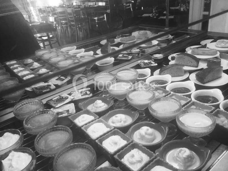 Vitrine de desserts variés comprenant tartes, crèmes et gâteaux, présentés dans un cadre de restaurant.