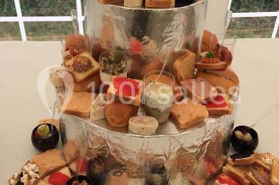 Plateau à plusieurs niveaux garni de toasts variés, verrines et amuse-bouches, présenté sur une table blanche.