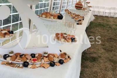 Plateau à plusieurs niveaux garni de toasts variés, verrines et amuse-bouches, présenté sur une table blanche.