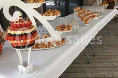 Plateau à plusieurs niveaux garni de toasts variés, verrines et amuse-bouches, présenté sur une table blanche.