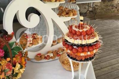 Plateau à plusieurs niveaux garni de toasts variés, verrines et amuse-bouches, présenté sur une table blanche.