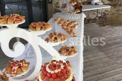 Plateau à plusieurs niveaux garni de toasts variés, verrines et amuse-bouches, présenté sur une table blanche.