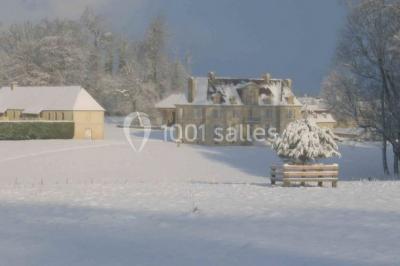 Grand espace vert avec des tentes blanches installées sur une pelouse, entouré d'arbres et d'un ciel partiellement nuageux.