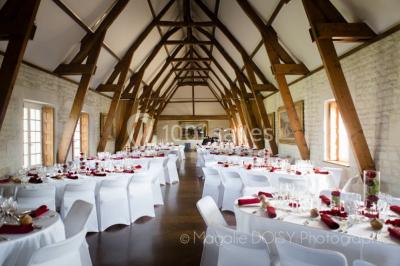 Grand espace vert avec des tentes blanches installées sur une pelouse, entouré d'arbres et d'un ciel partiellement nuageux.