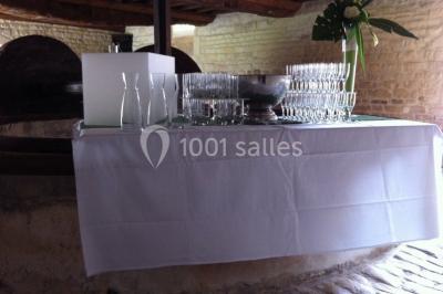 Grand espace vert avec des tentes blanches installées sur une pelouse, entouré d'arbres et d'un ciel partiellement nuageux.