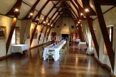 Grand espace vert avec des tentes blanches installées sur une pelouse, entouré d'arbres et d'un ciel partiellement nuageux.