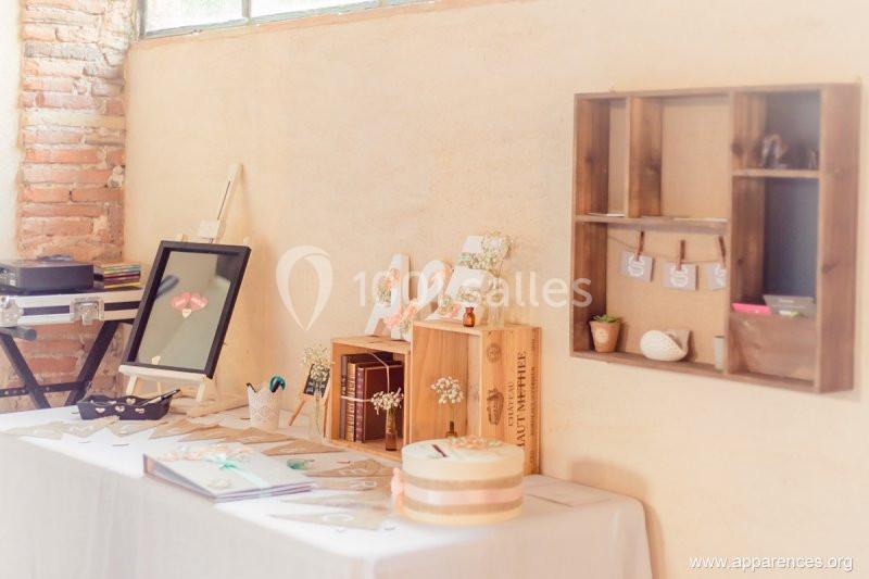 Décoration de table avec des objets en bois, cadres, livres et éléments floraux dans un intérieur lumineux.