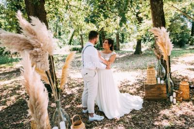 Un couple regarde un feu d'artifice illuminant le ciel nocturne, entouré d'arbres sombres.