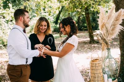 Un couple regarde un feu d'artifice illuminant le ciel nocturne, entouré d'arbres sombres.