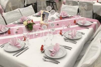 Canapé gris avec coussins, table basse avec magazines et télécommande, tableau mural et fenêtre laissant entrer la lumière.