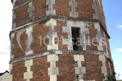 Canapé gris avec coussins, table basse avec magazines et télécommande, tableau mural et fenêtre laissant entrer la lumière.